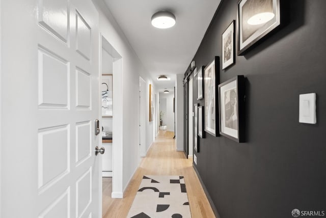 hall with baseboards and light wood-style flooring