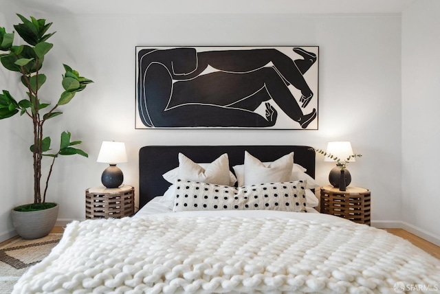 bedroom featuring wood finished floors and baseboards