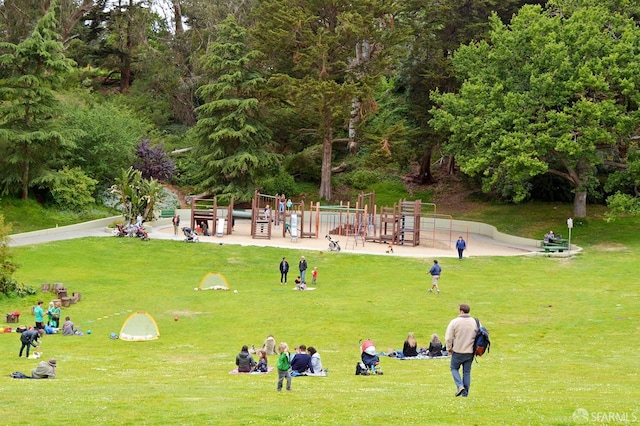 view of property's community featuring playground community and a yard