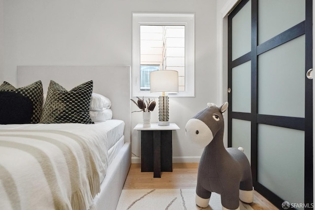 bedroom with baseboards and wood finished floors