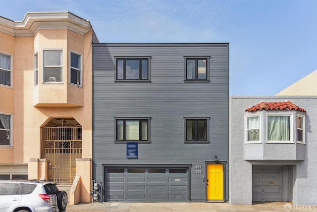 view of property featuring a garage, driveway, and stucco siding