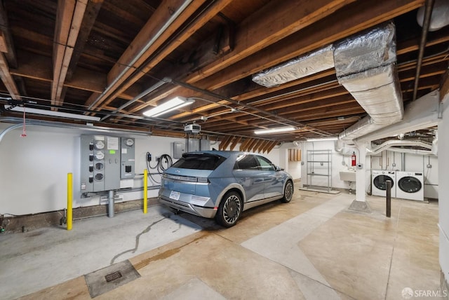 garage with a sink, a garage door opener, and washer and clothes dryer