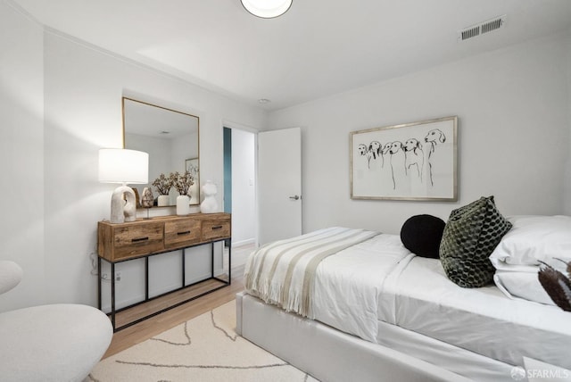 bedroom featuring wood finished floors and visible vents