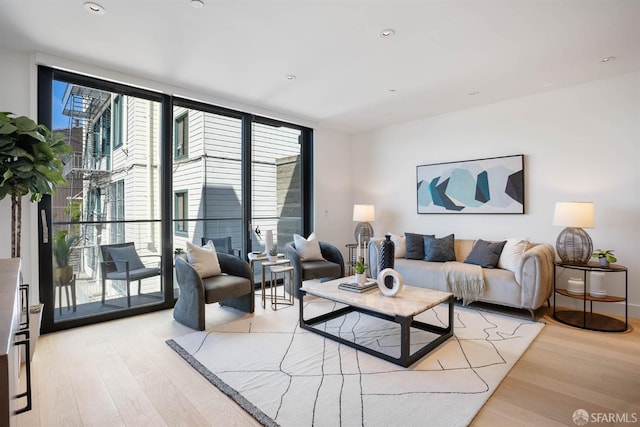 living room with expansive windows, plenty of natural light, and light hardwood / wood-style flooring