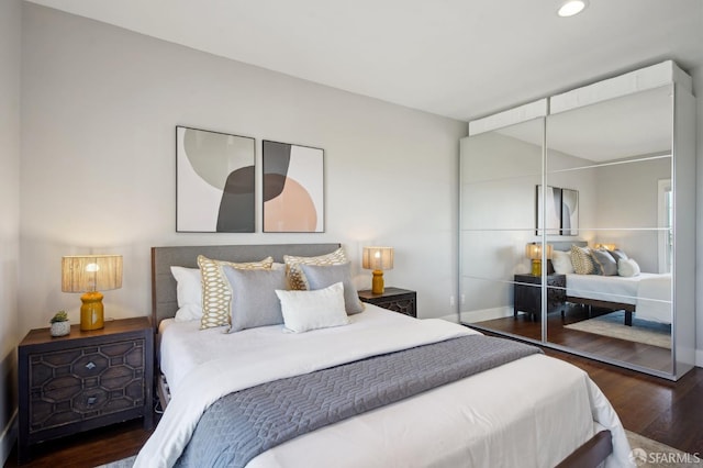 bedroom with wood finished floors, recessed lighting, and baseboards
