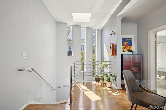 entryway featuring wood finished floors, a skylight, and baseboards
