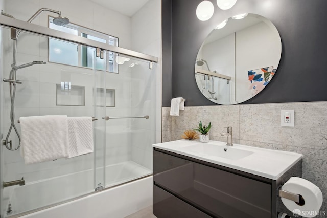 bathroom with tile walls, enclosed tub / shower combo, and vanity