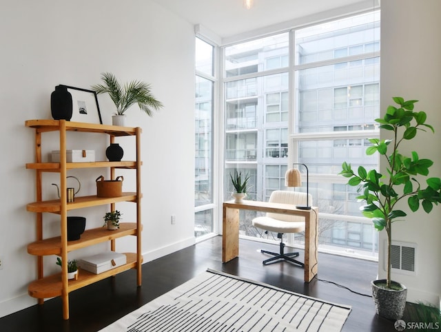 office with expansive windows, dark wood-type flooring, visible vents, and baseboards