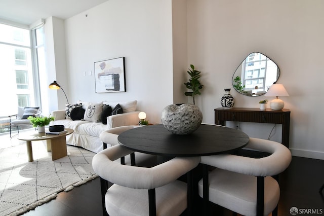 dining room with expansive windows, baseboards, and wood finished floors