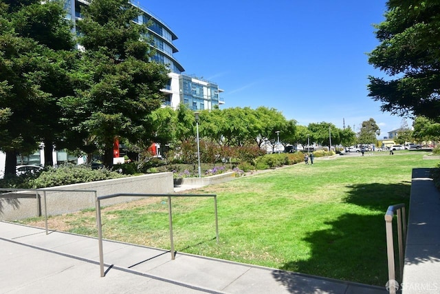 view of property's community with fence and a lawn