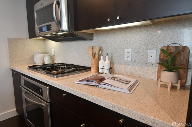 kitchen with appliances with stainless steel finishes, light countertops, and decorative backsplash