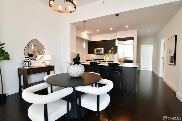 dining area featuring dark wood-style floors, recessed lighting, a notable chandelier, and baseboards