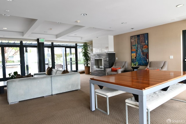 carpeted dining area with coffered ceiling, beamed ceiling, expansive windows, a brick fireplace, and recessed lighting