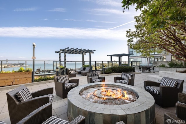 view of patio / terrace featuring a water view, a pergola, and an outdoor living space with a fire pit