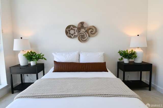 bedroom featuring baseboards and light colored carpet