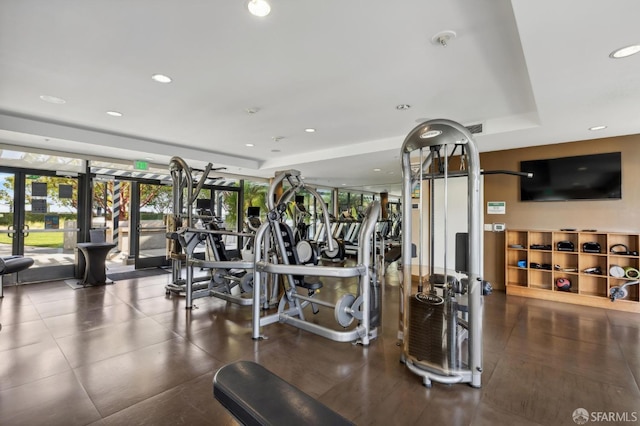 workout area featuring recessed lighting, a raised ceiling, and visible vents