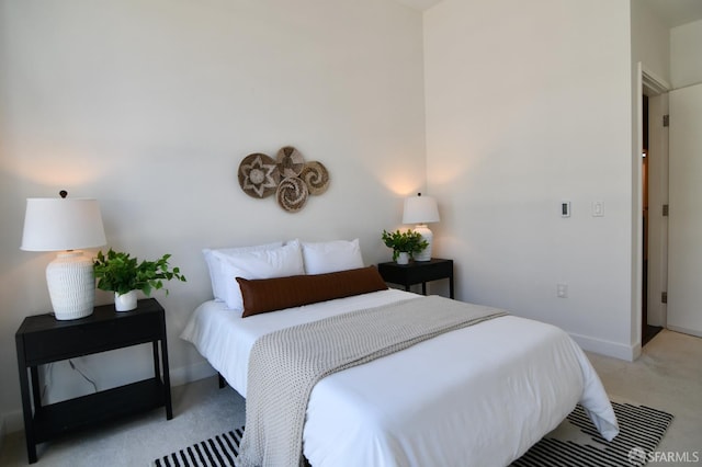 bedroom featuring light colored carpet and baseboards