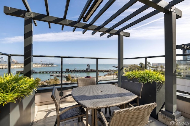 balcony with outdoor dining area and a water view