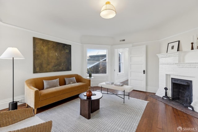 living room with a fireplace and wood-type flooring