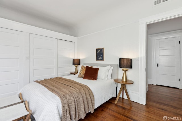 bedroom featuring dark hardwood / wood-style floors and a closet