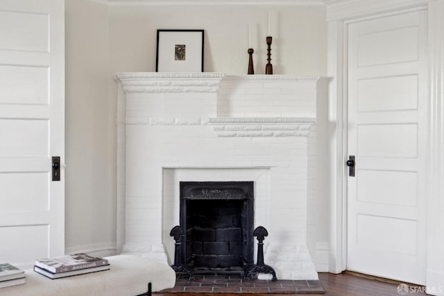 interior details featuring a fireplace, crown molding, and hardwood / wood-style floors