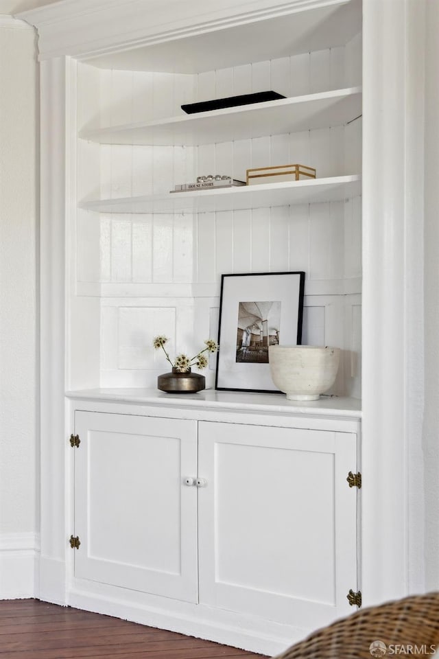 bar with white cabinetry and dark hardwood / wood-style flooring