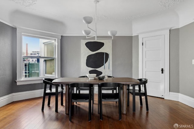 dining area featuring dark wood-type flooring and a notable chandelier