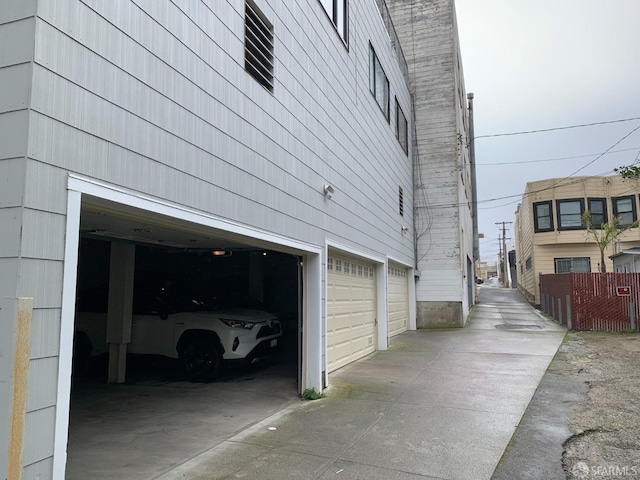 view of home's exterior with a garage and fence