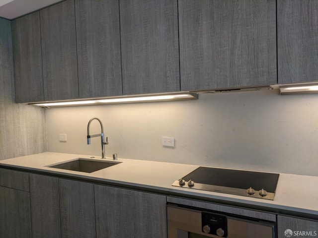 kitchen with oven, sink, and cooktop