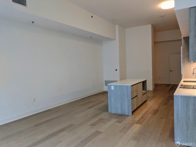 kitchen with sink, light hardwood / wood-style flooring, and a kitchen island