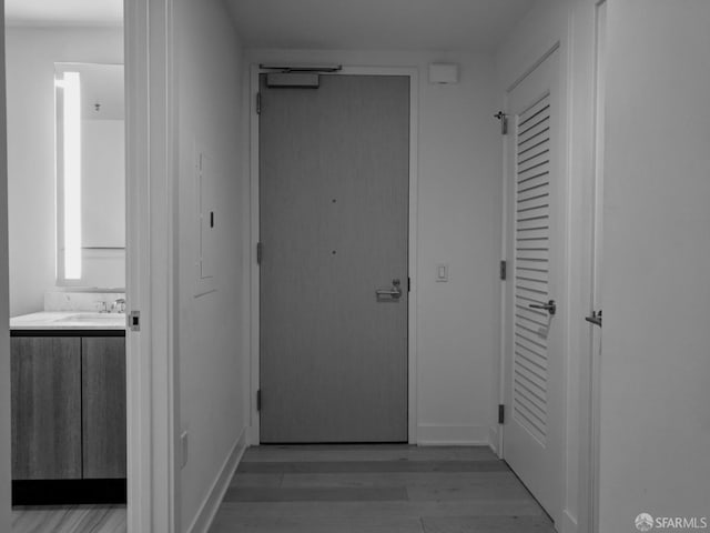 corridor featuring wood-type flooring and sink