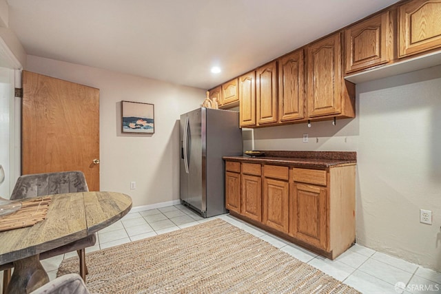 kitchen with light tile patterned floors and stainless steel fridge