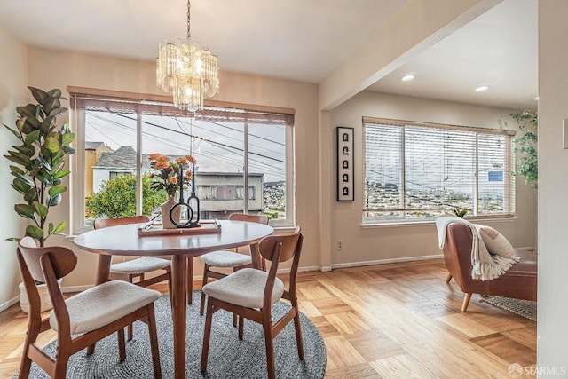 dining space featuring an inviting chandelier, light parquet flooring, and a healthy amount of sunlight