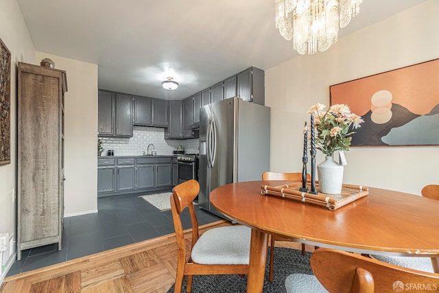 tiled dining room featuring sink and a chandelier