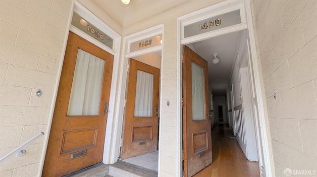 hallway featuring wood finished floors and concrete block wall