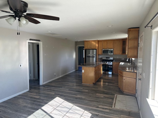 kitchen featuring sink, dark wood-type flooring, appliances with stainless steel finishes, and a kitchen island