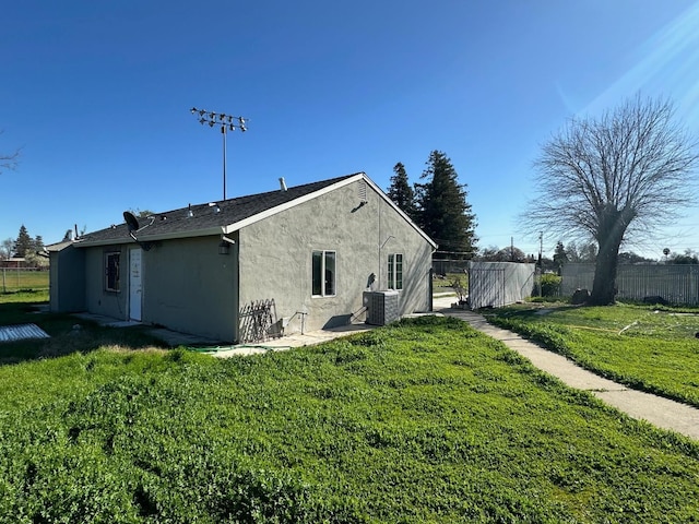 view of home's exterior with cooling unit and a lawn