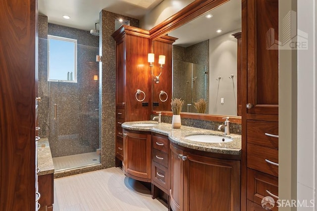 bathroom with a tile shower and vanity