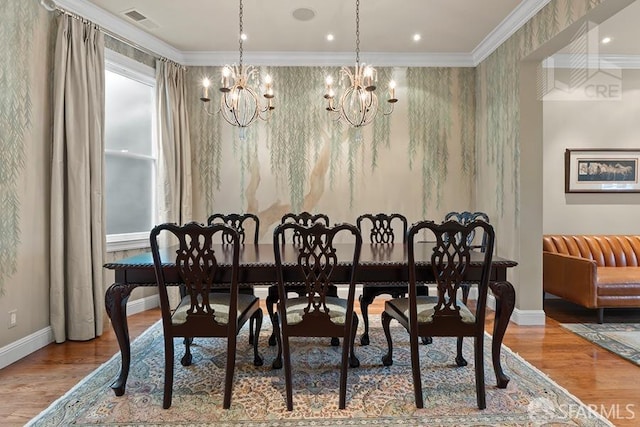 dining room featuring crown molding, hardwood / wood-style floors, and a notable chandelier