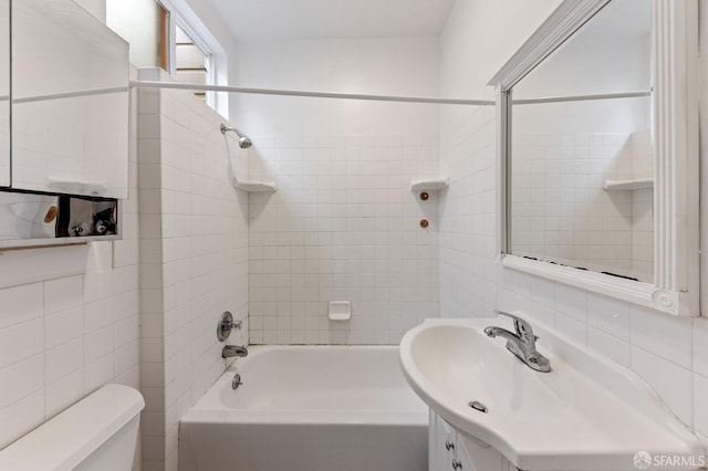 full bathroom featuring tasteful backsplash, vanity, tile walls, toilet, and tiled shower / bath