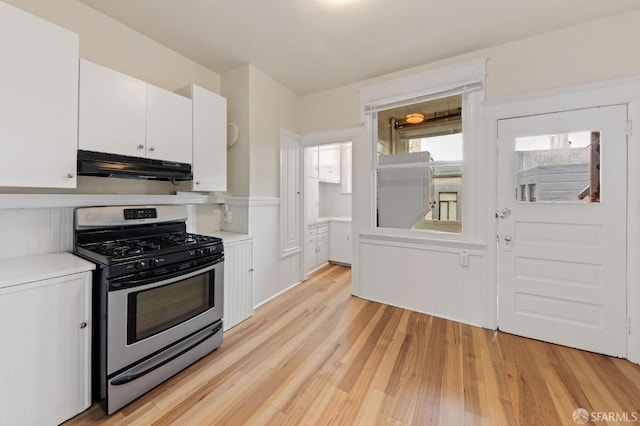 kitchen featuring stainless steel gas range oven, white cabinetry, and light wood-type flooring