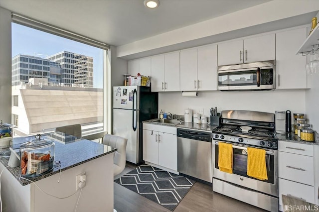 1400 Mission St, San Francisco, CA 94103 - kitchen featuring stainless steel appliances, dark wood-type flooring, white cabinets, and recessed lighting