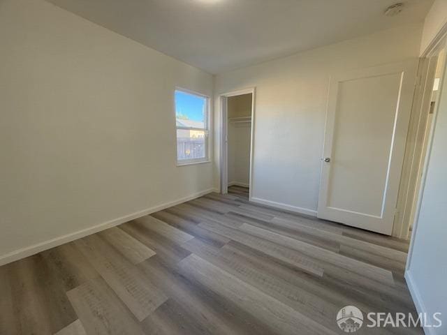 unfurnished bedroom with light hardwood / wood-style flooring and a closet