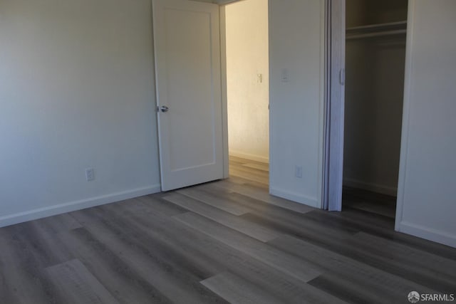 unfurnished bedroom featuring wood-type flooring and a closet