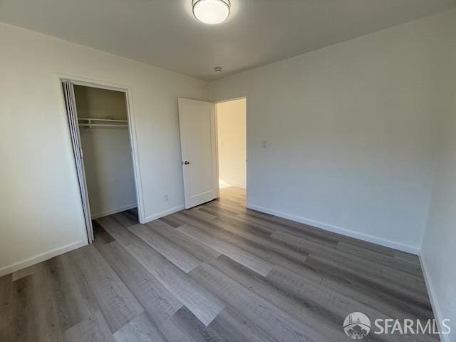 unfurnished bedroom with a closet and light hardwood / wood-style floors