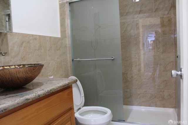 bathroom featuring vanity, toilet, and a shower with door