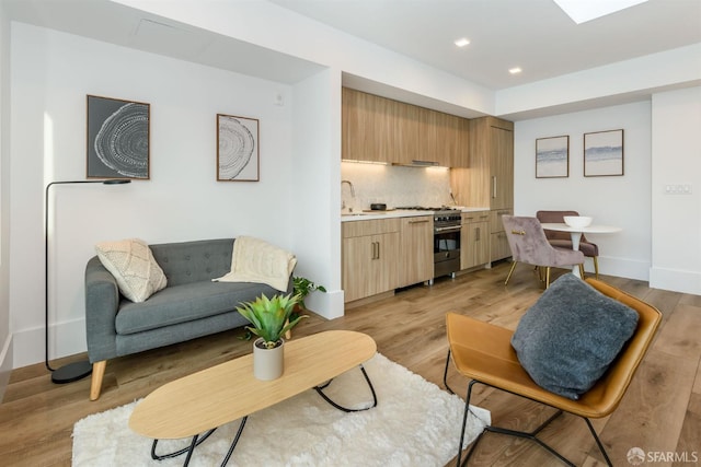 living room featuring recessed lighting, light wood-style flooring, and baseboards