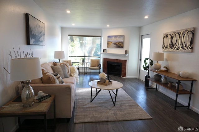 living room featuring recessed lighting, baseboards, dark wood-type flooring, and a tiled fireplace