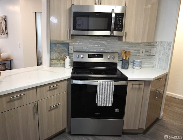 kitchen featuring tasteful backsplash, light brown cabinets, dark wood-type flooring, light stone counters, and stainless steel appliances