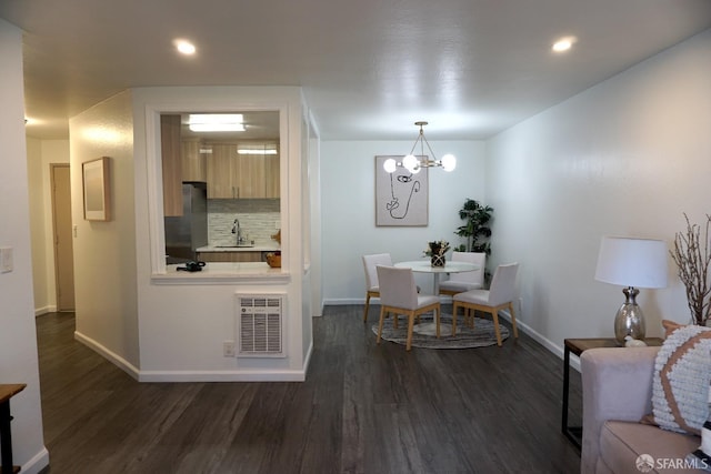 dining room with an inviting chandelier, baseboards, and dark wood-style flooring